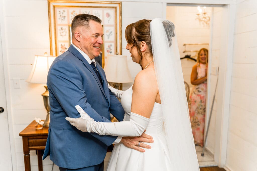 The bride's dad's reaction during their first look and her mom watching in the background.