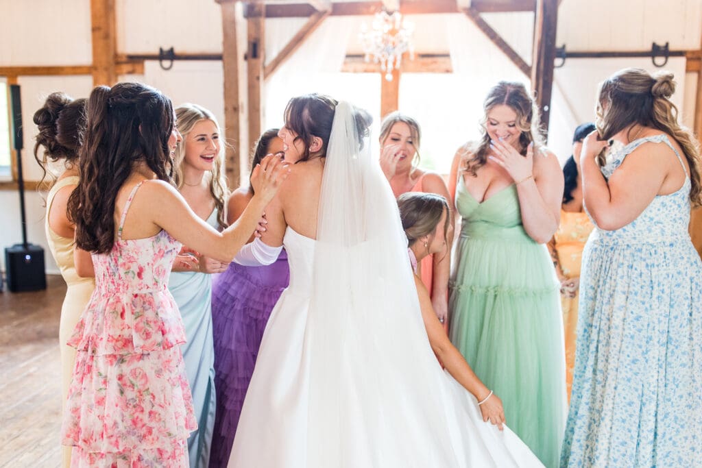 Bridesmaids react and embrace bride after first look at Rivercrest Farms.