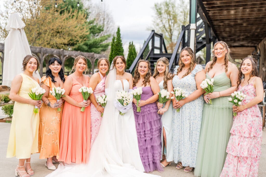 Bride and her bridesmaids in colorful, textured gowns at Rivercrest Farms in Dover, Ohio.