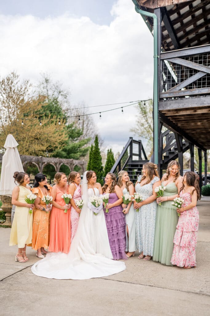 Bride and her bridesmaids in colorful, textured gowns at Rivercrest Farms in Dover, Ohio.