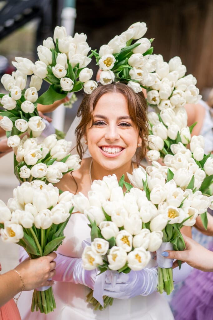 Bridesmaids hold bouquets around bride at Rivercrest Farms in Dover, Ohio.