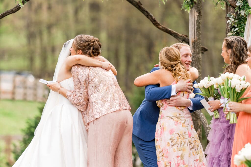 Couple hugs their moms during their ceremony at Rivercrest Farms in Dover, Ohio.