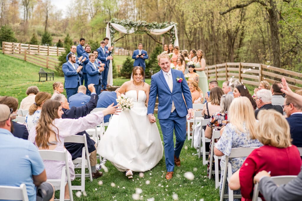 Guests throw flower petals during the recessional at Rivercrest Farms in Dover, Ohio.
