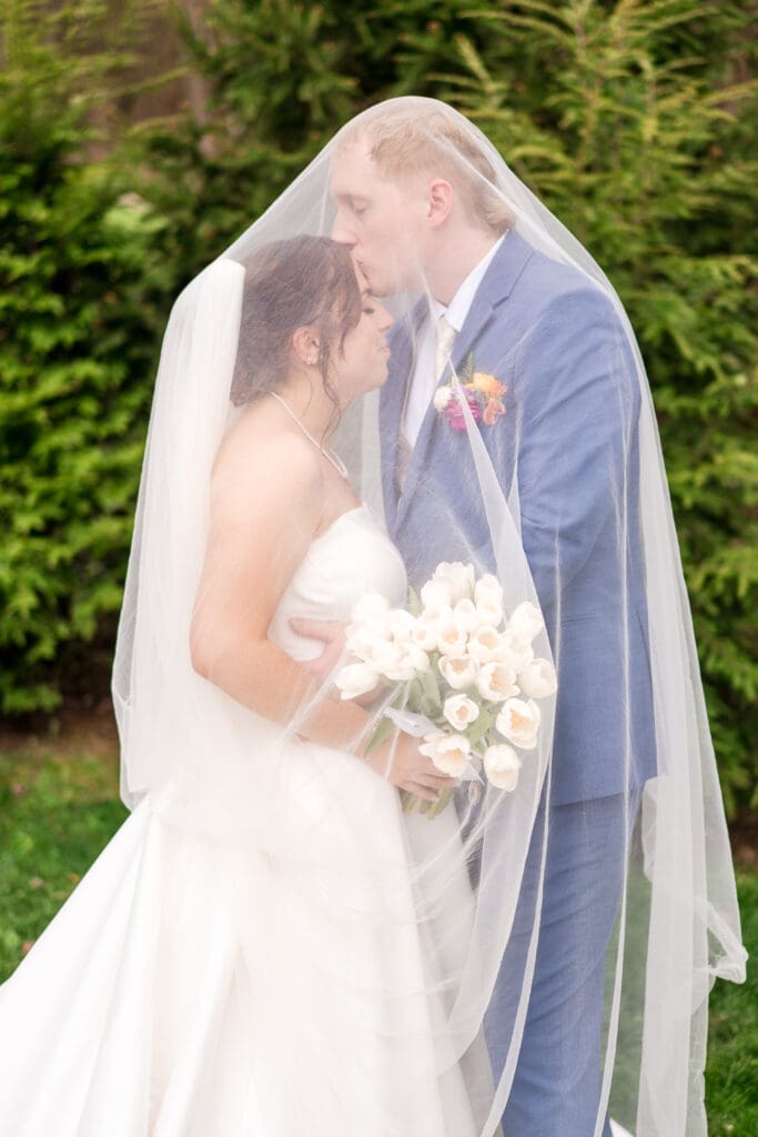 Couple under veil at their wedding at Rivercrest Farms in Dover, Ohio.