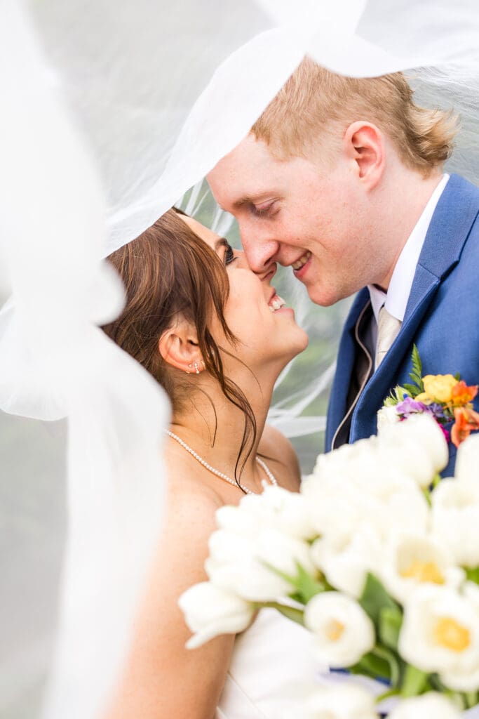 Couple under veil at their wedding at Rivercrest Farms in Dover, Ohio.