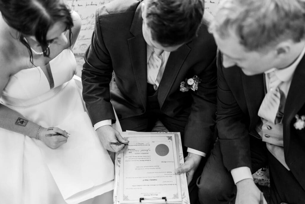 Couple and officiant sign marriage license.
