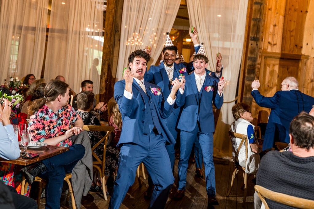 Groomsmen shoot squirt guns as they enter the reception at Rivercrest Farms.