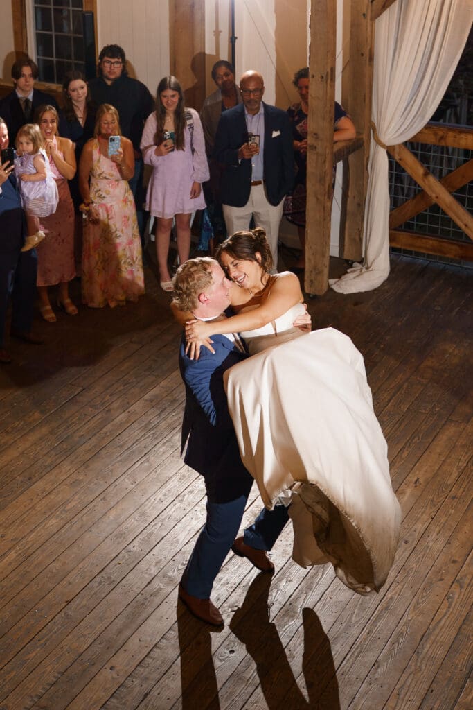 Groom holds bride in his arms and spins her.