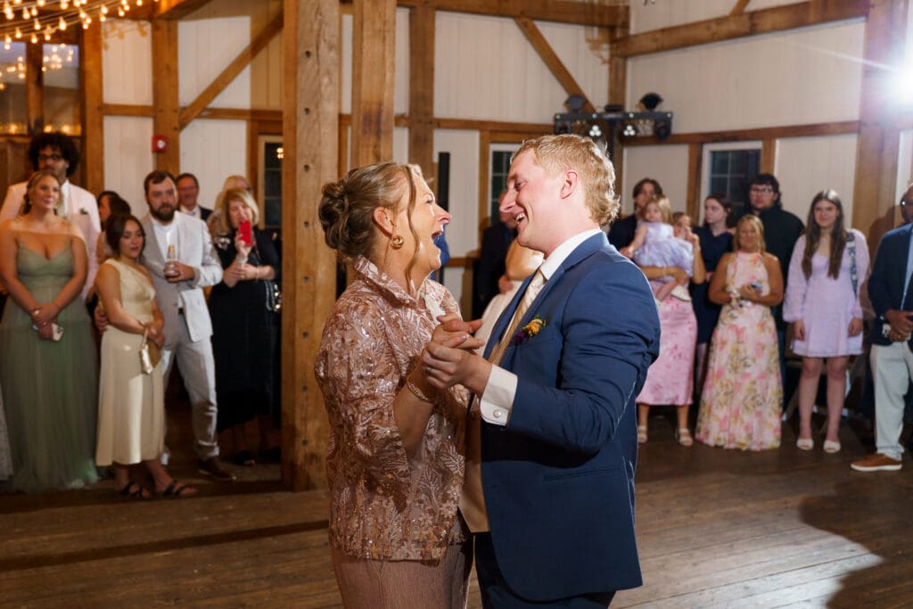 Groom and his mom laugh as they dance.