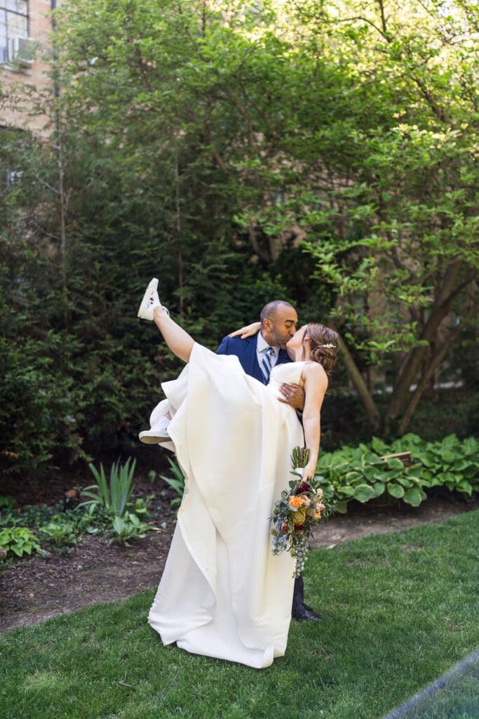 The groom picks up his bride as they kiss at the Kelton House in Columbus, Ohio