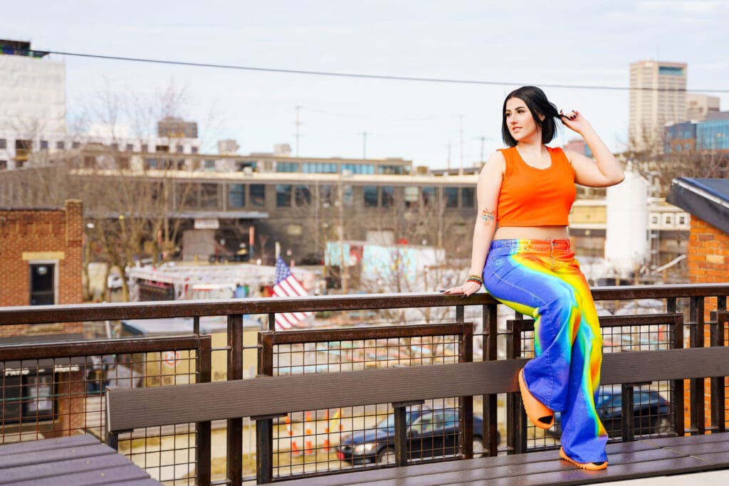 Senior in bright streetwear on a rooftop in Franklinton Columbus, Ohio.