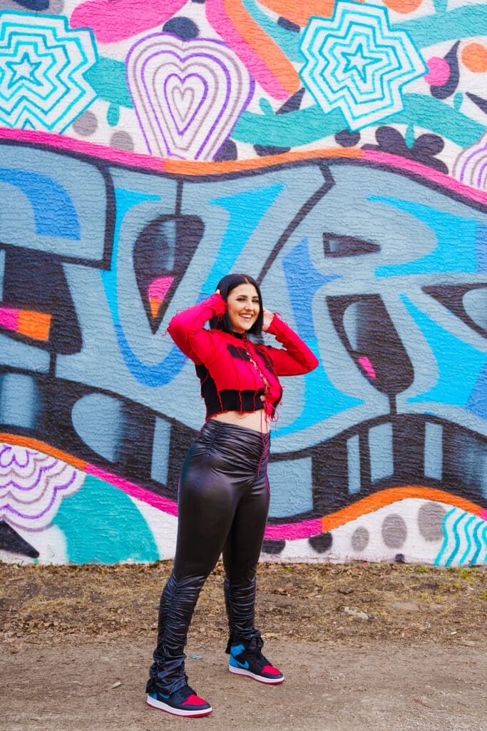 Senior in streetwear by graffiti in Franklinton Columbus, Ohio.