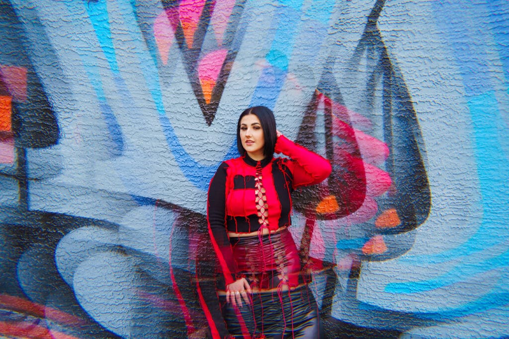 Senior in streetwear by graffiti in Franklinton Columbus, Ohio.