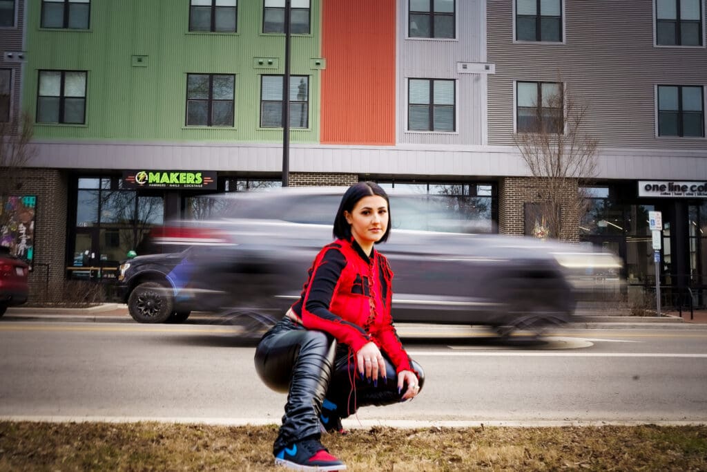 Senior in streetwear in front of moving cars in Franklinton Columbus, Ohio.