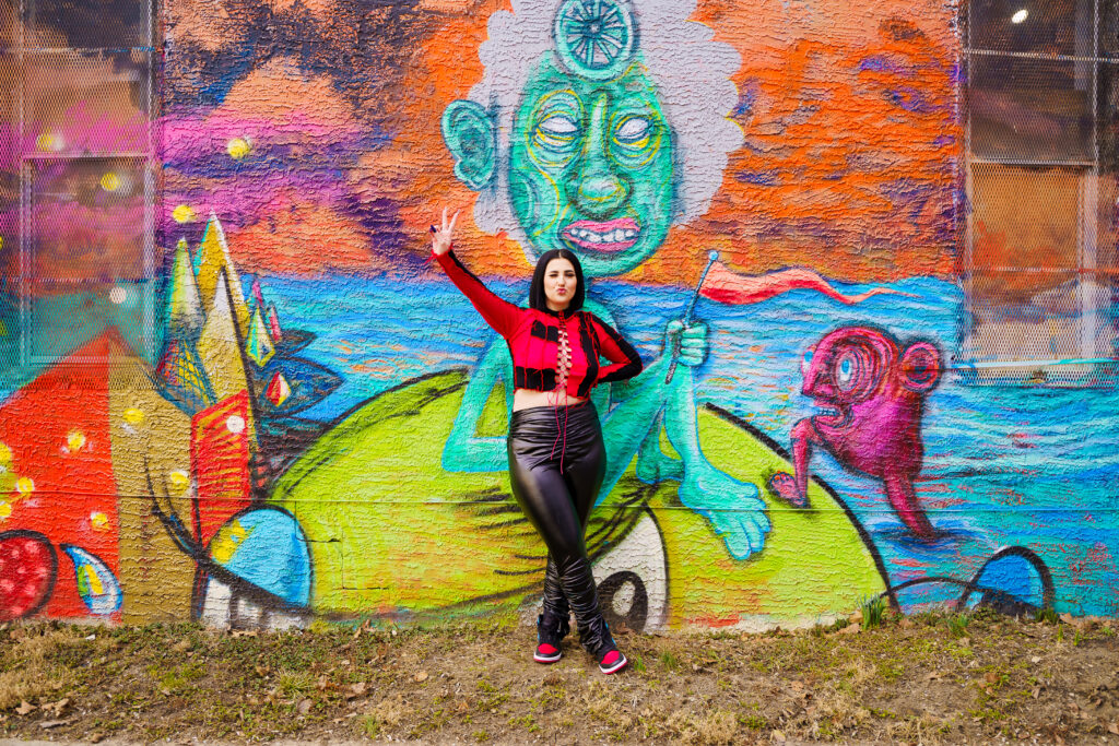 Senior in streetwear by graffiti in Franklinton Columbus, Ohio.