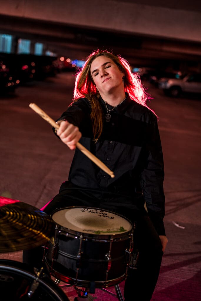 Senior with drum set in a parking garage in Columbus, Ohio.
