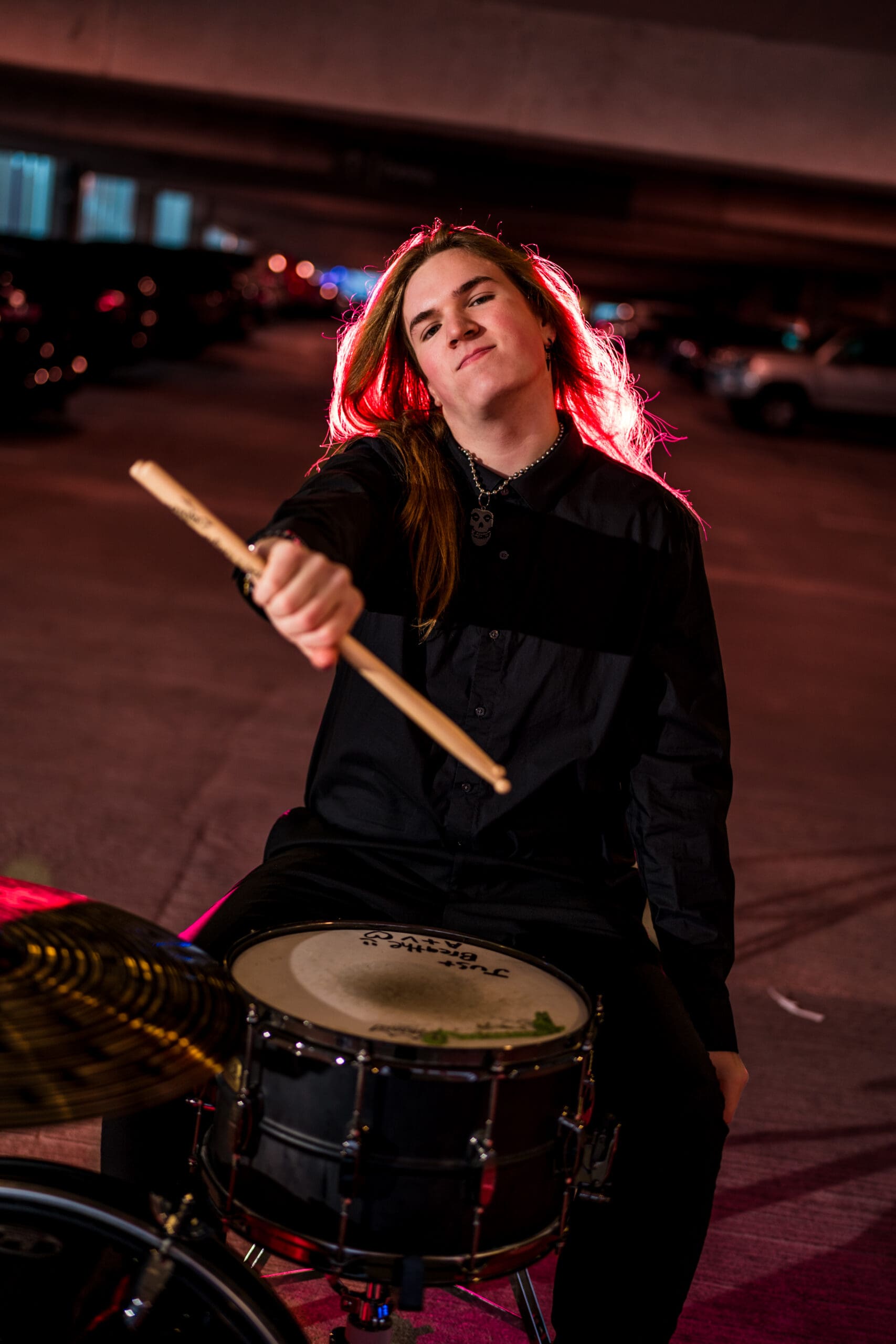 Senior with drum set in a parking garage in Columbus, Ohio.