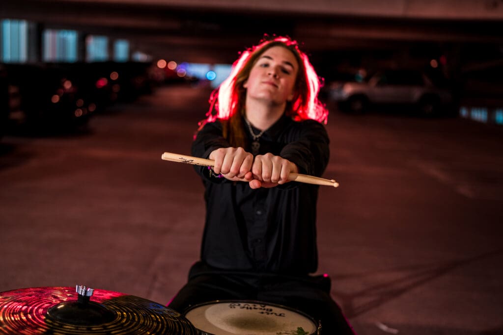 Senior with drum set in a parking garage in Columbus, Ohio.
