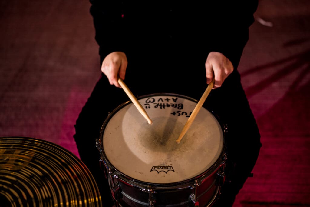 Senior with drum set in a parking garage in Columbus, Ohio.