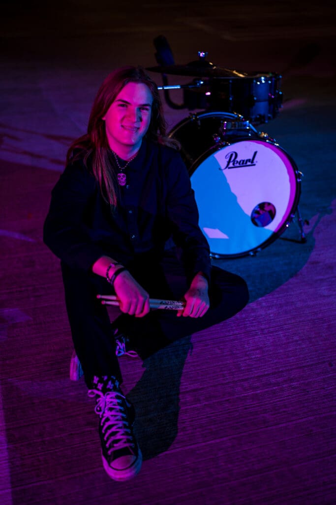 Senior with drum set in a parking garage in Columbus, Ohio.