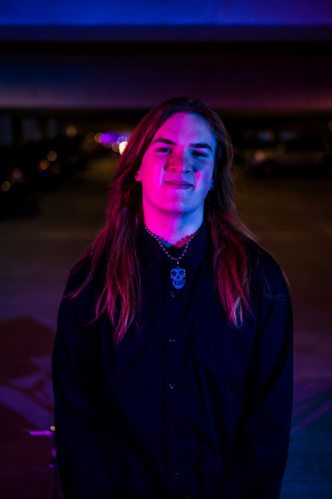 Senior with drum set in a parking garage in Columbus, Ohio.
