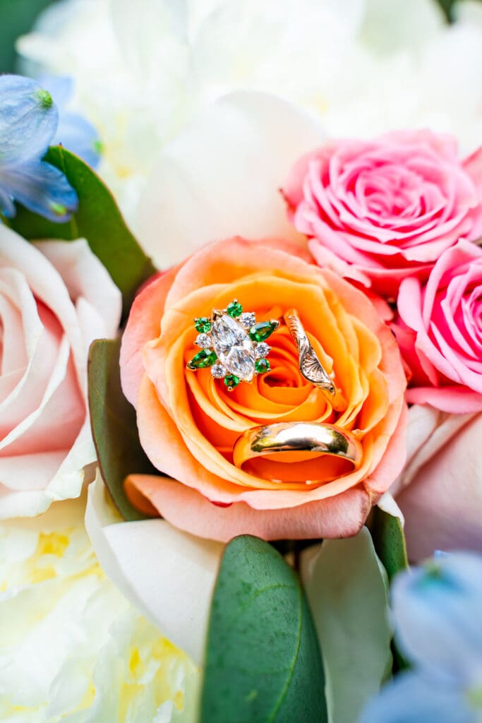 Three unique wedding rings in a colorful bouquet.