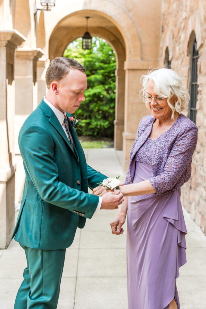 The groom put a corsage on his mother.