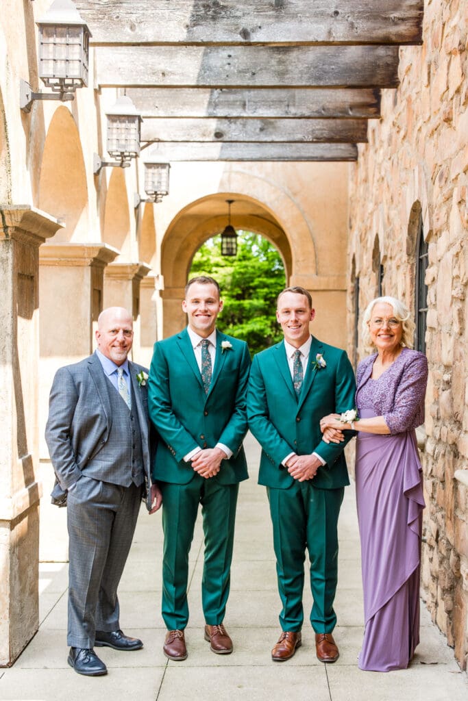 The groom and his family stand for a formal family photo.