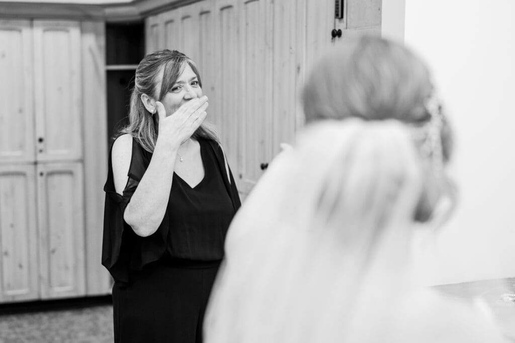 Mother of the bride gets emotional seeing her daughter in her gown and veil.