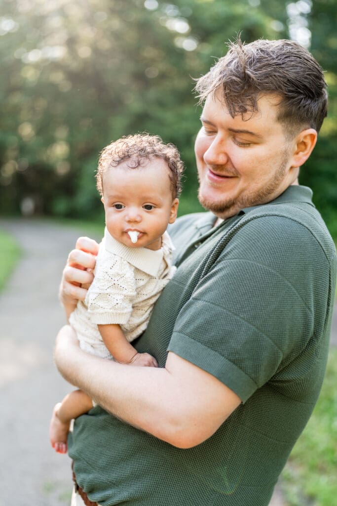 A baby boy throws up on his dad during their family photos.