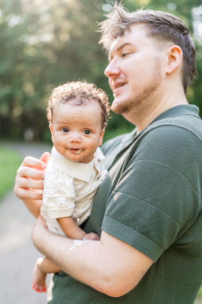 A baby boy throws up on his dad during their family photos.