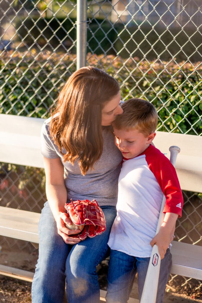 Mother kisses her son's forehead in the dugout in Canal Winchester, Ohio.