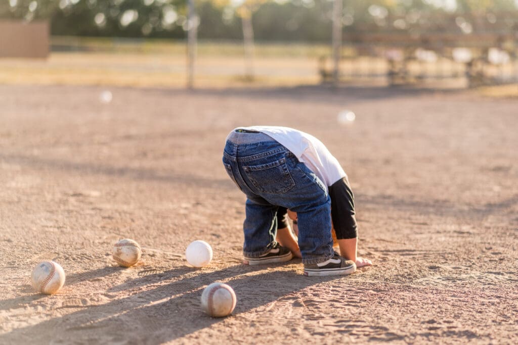 Little boy plays in the sand on a baseball field in Canal Winchester, Ohio.