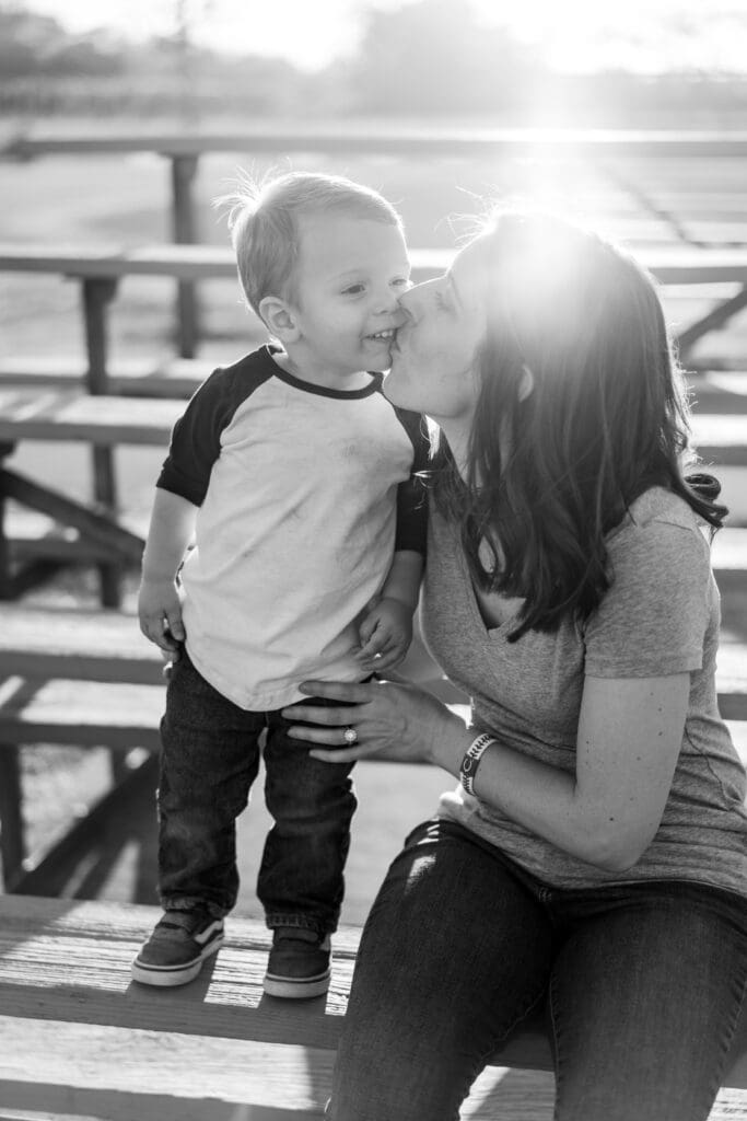 Mother and son sit in the bleachers at a baseball field in Canal Winchester, Ohio.