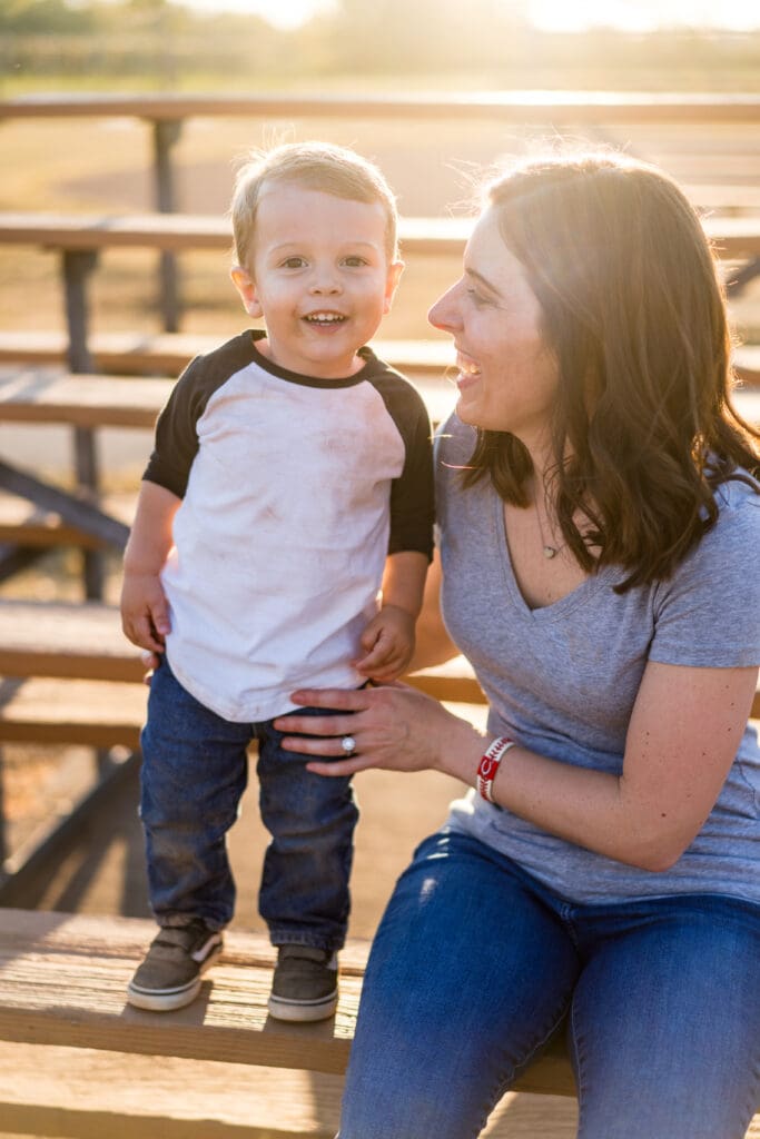Mother and son sit in the bleachers at a baseball field in Canal Winchester, Ohio.