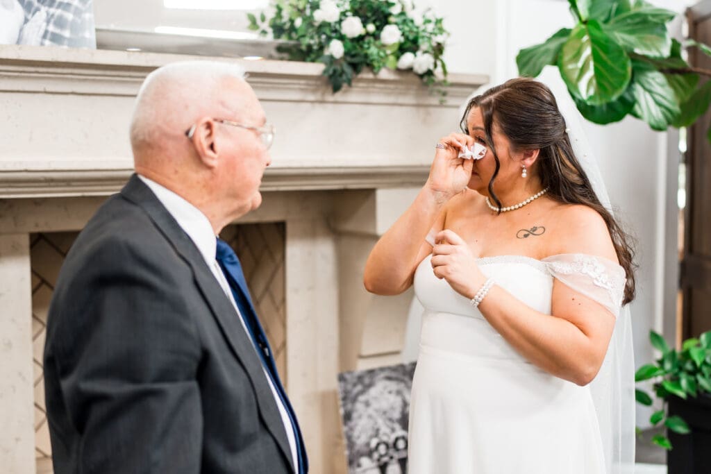 Bride wipes away a tear during her first look with her grandpa at The Estate at New Albany.