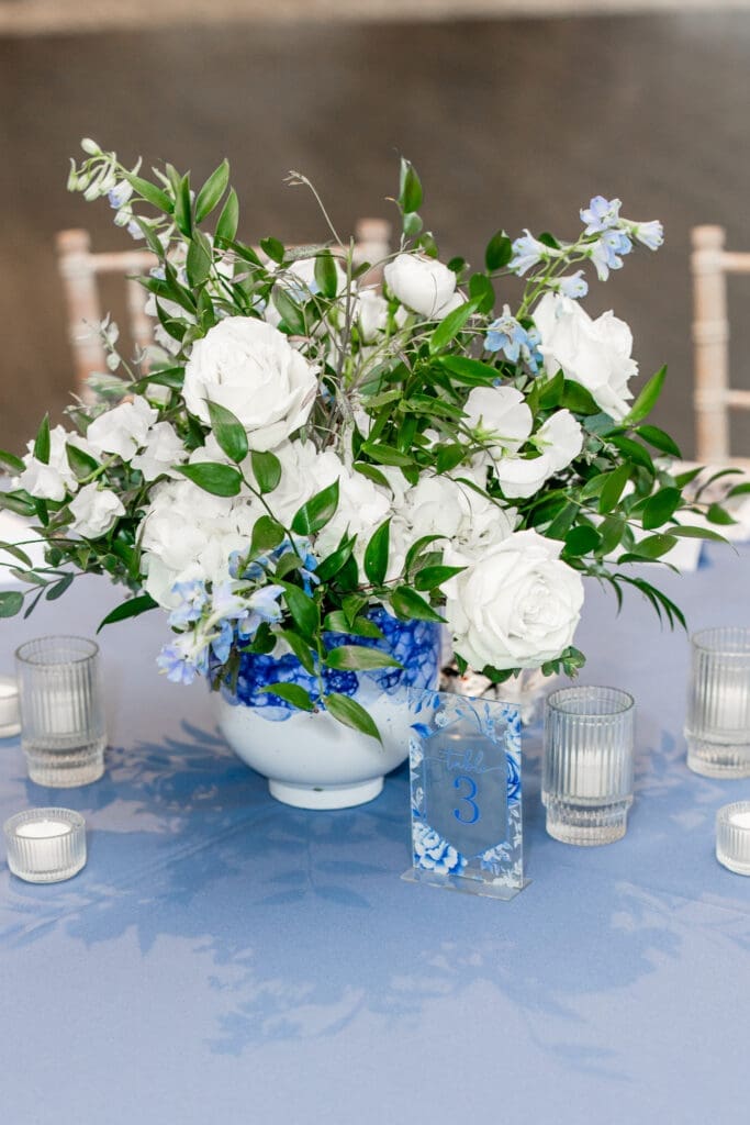 White flower arrangement with blue decor on a table at the Estate at New Albany