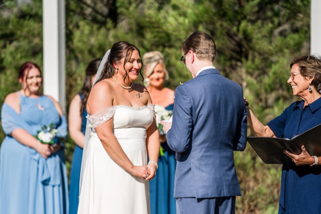 Bride smiles during the groom's vows