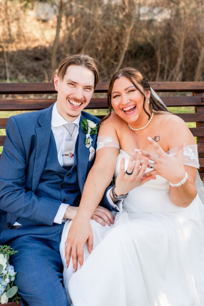 Couple smiles as they hold up their rings at the Estate at New Albany
