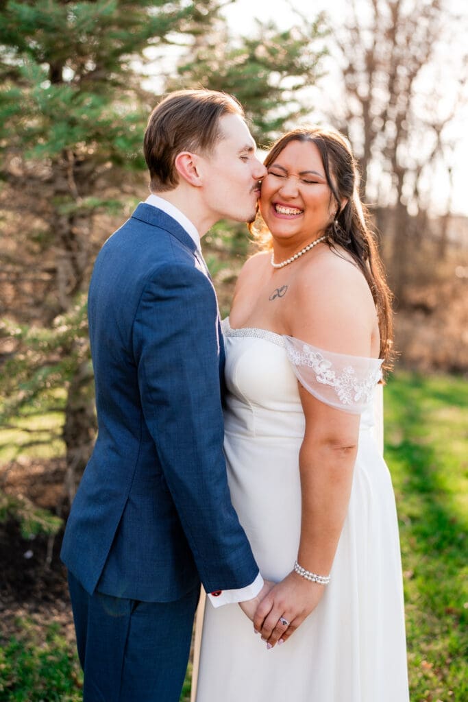 Groom kisses the bride's cheek during their couple portraits at the Estate at New Albany