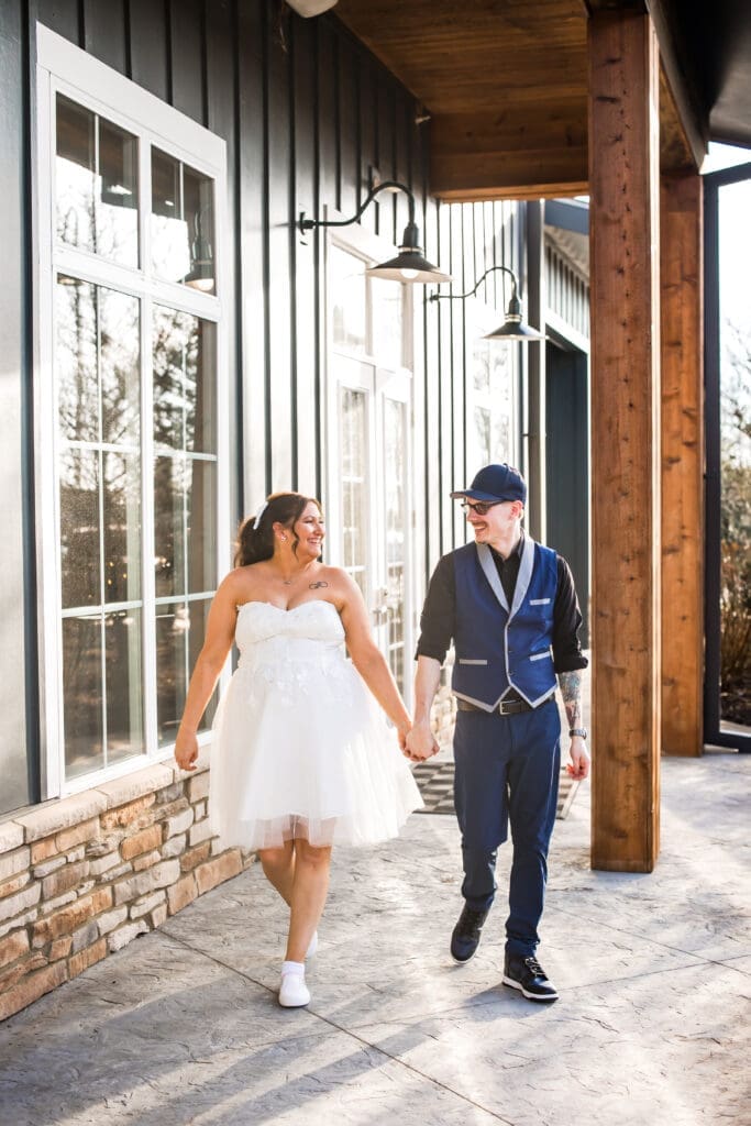 Couple holds hands and walks during their couple portraits at the Estate at New Albany