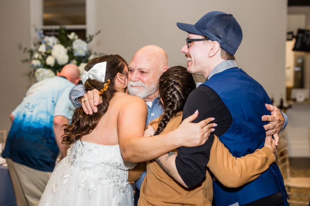 Bride and groom hug the couple who's been together the longest