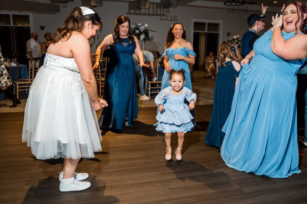 Little girl and others dance on the dancefloor