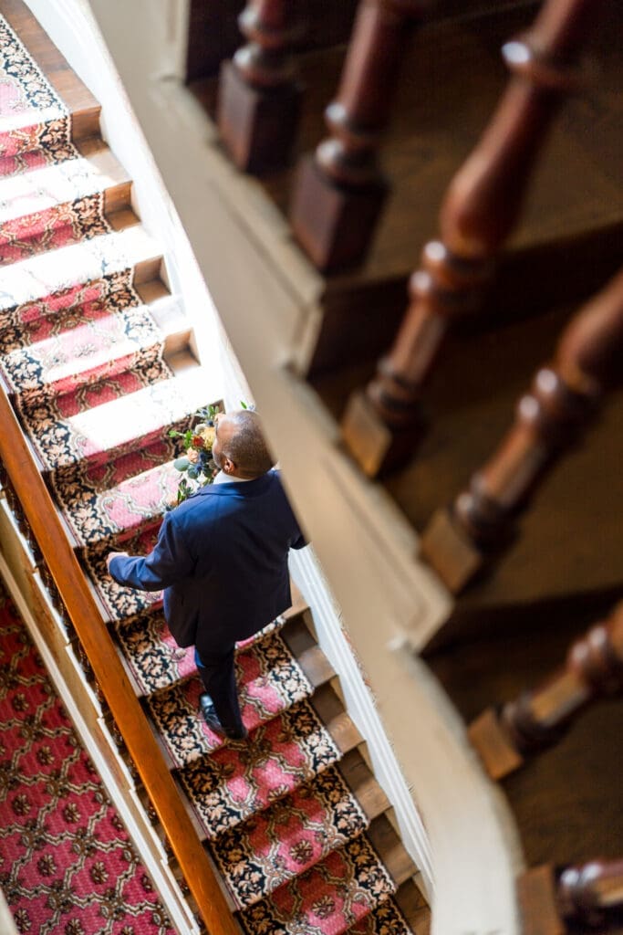 Staircase photo of a groom walking up the steps at the Kelton House in Columbus, Ohio