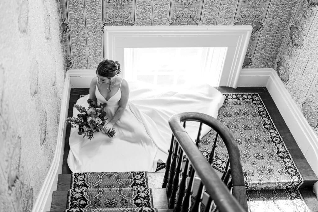 Bride sits on the landing of a staircase at the Kelton House in Columbus, Ohio