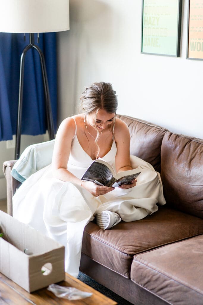 The bride reads a book in her hotel room while she waits to go to her ceremony