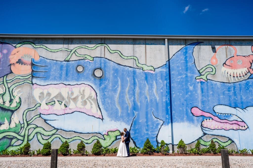 Bride and groom in front of a mural at BrewDog in Columbus, Ohio.