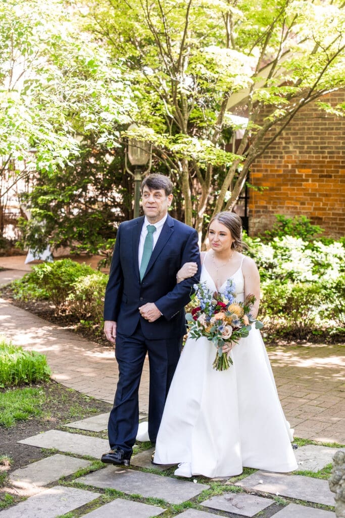 The bride and her father walking to the ceremony in the garden at the Kelton House in Columbus, Ohio