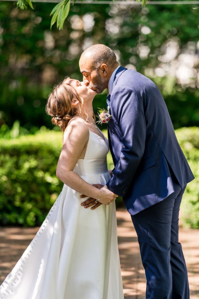 The bride and groom's first kiss at their garden micro-wedding ceremony at the Kelton House in Columbus, Ohio.