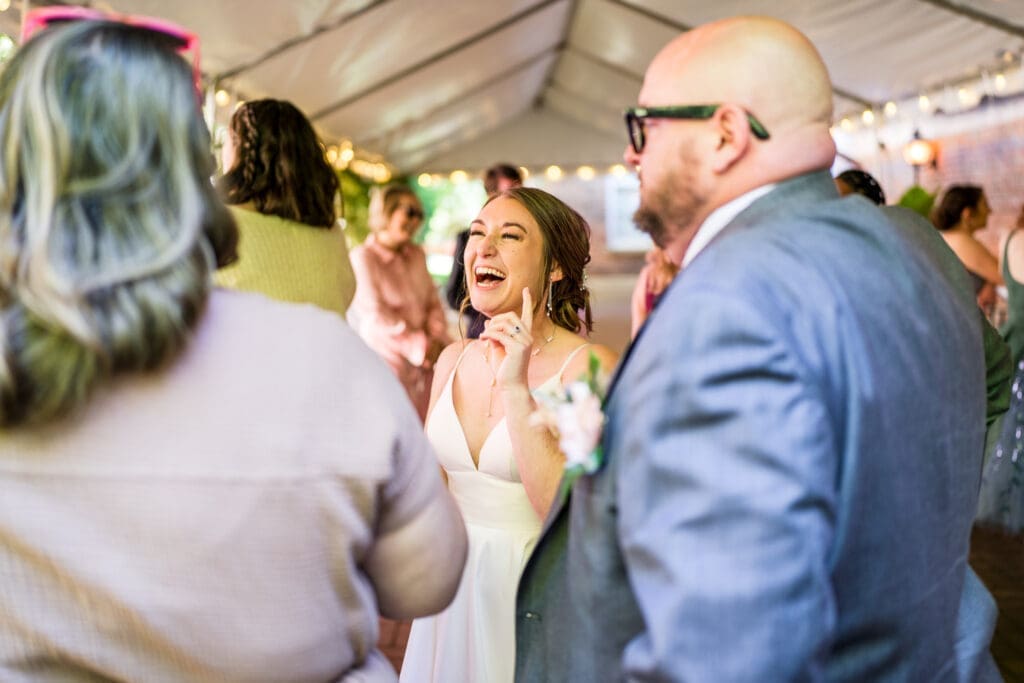 The bride talks to her guests at their tented cocktail hour at the Kelton House